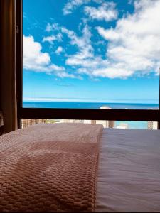 a view of the ocean from a bedroom window at Aston Waikiki Sunset Ocean view in Honolulu