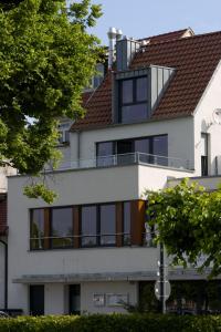 a house with a balcony on top of it at Hommage Appartements in Waren