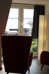 a living room with a chair and a window at Hommage Appartements in Waren