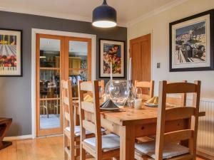a dining room with a wooden table and chairs at 1 The Courtyard in Kinneff