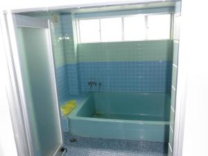 a bathroom with a blue tub and a window at ペンションレークサイド in Otsu +57 photos