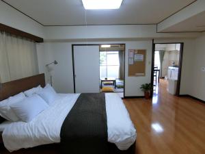 ein Schlafzimmer mit einem großen Bett in einem Zimmer in der Unterkunft Simple Stay Beppu in Beppu