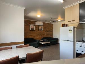 eine Küche mit einem weißen Kühlschrank sowie einem Tisch und Stühlen in der Unterkunft Marlo Caravan Park & Motel in Marlo