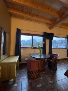 a dining room with a table and chairs and windows at Ma Petite Maison in Tepoztlán