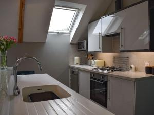 uma cozinha com um lavatório e uma bancada em Priory Barn em Freshwater