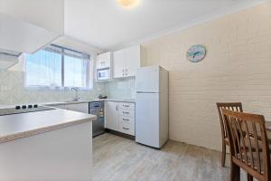 a kitchen with white appliances and a white refrigerator at Apollo Unit 14 1st Floor in Narooma