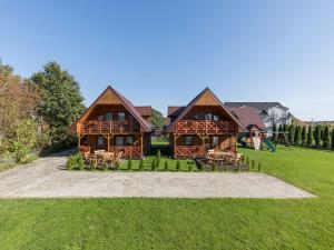 una gran casa de madera con un parque infantil en el patio en Big Cottages in Rewal en Rewal