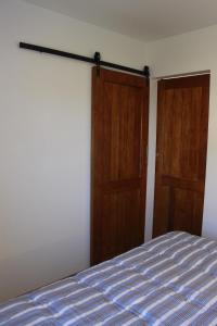 een slaapkamer met 2 houten deuren en een bed bij Meraki Lofts in El Chalten