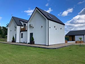 a white house with a black roof at Holiday Home in winouj cie with Pool in Świnoujście