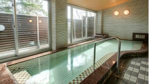 uma piscina num quarto com janelas em Kyukamura Kesennuma-Ohshima em Kesennuma