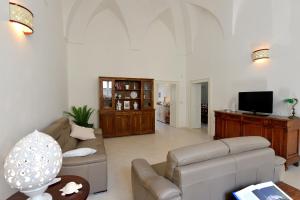 ein Wohnzimmer mit einem Sofa und einem TV in der Unterkunft B&B Santachiara in Manduria