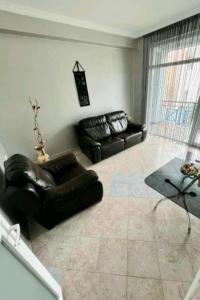 a living room with two leather couches and a table at Hotel Rio Gonio in Gonio