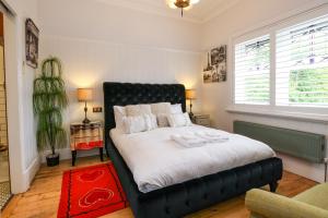 um quarto com uma cama grande e uma cabeceira preta em Vintage Charm On St Leonards em Healesville
