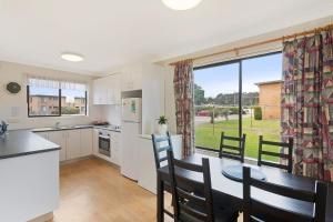 a kitchen and dining room with a table and chairs at Apollo Unit 17 Ground Floor in Narooma