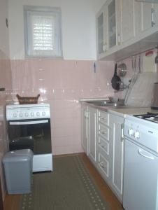 a kitchen with a white stove and a white oven at Apartments RUDO in Podaca