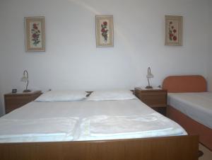 a bedroom with two beds and two lamps on two tables at Apartments RUDO in Podaca