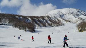 grupa ludzi jeżdżących na nartach po śniegu pokrytej górze w obiekcie Kyukamura Nasu w mieście Nasu