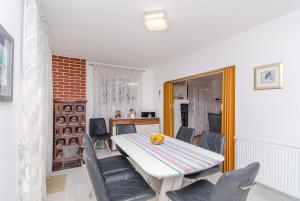 a dining room with a white table and chairs at Apartment Vito in Postira