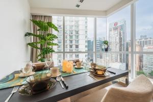 a dining room with a table and a large window at 2BR Tourists-Friendly Oasis - Heart of the City KL by Verano in Kuala Lumpur