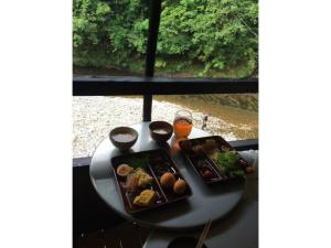 una mesa con dos platos de comida y un vaso de cerveza en Kumano shiki-tei - Vacation STAY 05155v en Hongu