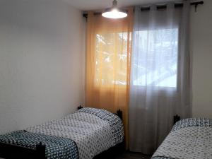 a bedroom with two beds and a window with curtains at Appartement Villard-de-Lans, 3 pièces, 6 personnes - FR-1-689-16 in Villard-de-Lans