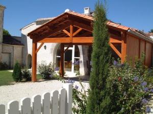 un padiglione in legno in un giardino con recinzione bianca di Gîte familial avec piscine chauffée, jardin privé et équipements bébé en pleine propriété viticole. - FR-1-653-18 a Saint-Cybardeaux