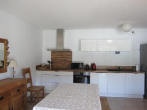 uma cozinha com armários brancos, uma mesa e um balcão em Appartement Villard-de-Lans, 3 pièces, 6 personnes - FR-1-689-12 em Villard-de-Lans