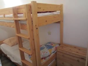 a wooden bunk bed with a ladder next to a bed at Appartement Villard-de-Lans, 2 pièces, 6 personnes - FR-1-689-19 in Villard-de-Lans