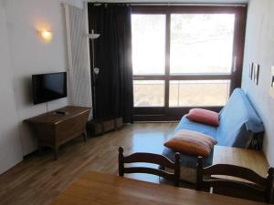 a living room with a blue couch and a television at Appartement Villard-de-Lans, 2 pièces, 6 personnes - FR-1-689-19 in Villard-de-Lans