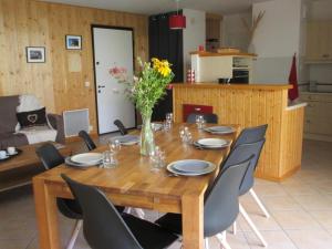 een houten tafel met stoelen en een vaas met bloemen bij Appartement Villard-de-Lans, 3 pièces, 7 personnes - FR-1-689-18 in Villard-de-Lans
