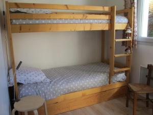 a bedroom with two bunk beds and a chair at Appartement Villard-de-Lans, 3 pièces, 7 personnes - FR-1-689-18 in Villard-de-Lans