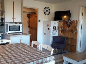 eine Küche mit einem Tisch und einem Kühlschrank in der Unterkunft Appartement Villard-de-Lans, 2 pièces, 6 personnes - FR-1-689-32 in Villard-de-Lans