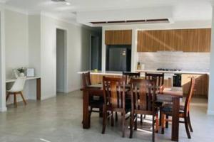 a kitchen and dining room with a table and chairs at Entire 4 Bedroom Brand New Home In Melton South ! in Melton South