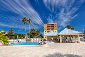 a pool at a resort with palm trees and a building at #1 Stunning Ocean View completely remodeled luxury condo with huge balcony in Clearwater Beach