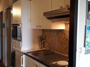 a kitchen with white cabinets and a sink at Studio Villard-de-Lans, 1 pièce, 4 personnes - FR-1-689-46 in Villard-de-Lans