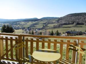 una silla de madera sentada en un balcón con vistas en Studio Corrençon-en-Vercors, 1 pièce, 5 personnes - FR-1-689-62, en Corrençon-en-Vercors