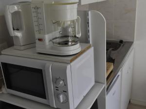 a white blender sitting on top of a microwave at Studio Villard-de-Lans, 1 pièce, 4 personnes - FR-1-689-84 in Villard-de-Lans