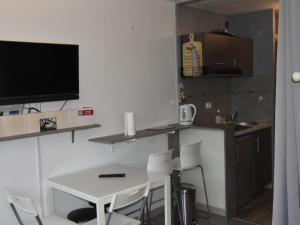 a kitchen with a table and chairs and a television at Studio Villard-de-Lans, 1 pièce, 4 personnes - FR-1-689-55 in Villard-de-Lans