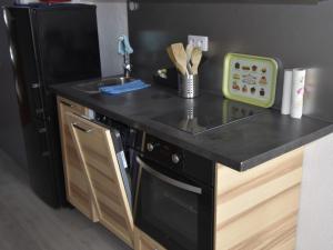 a kitchen with a black counter top and a dishwasher at Studio Villard-de-Lans, 1 pièce, 4 personnes - FR-1-689-87 in Villard-de-Lans