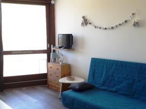 sala de estar con sofá azul y TV en Studio Villard-de-Lans, 1 pièce, 4 personnes - FR-1-689-92, en Villard-de-Lans