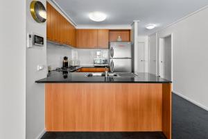 a kitchen with a sink and a refrigerator at Exclusive Stays - The Summit in Melbourne