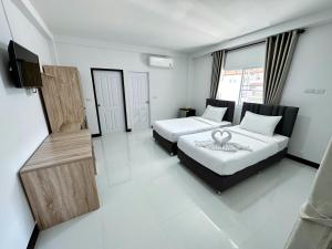 a hotel room with two beds and a television at The Wisdom Residence in Bung Kan