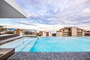 a large swimming pool on the roof of a building at Skyloftpv by LOFT268 in Puerto Vallarta