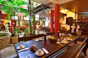 a restaurant with a wooden table with dishes on it at Pousada Estalagem do Porto in Arraial do Cabo