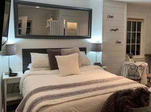 a bedroom with a large bed with a mirror on the wall at Amante Luxury Bed & Breakfast in Victoria
