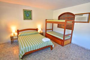 a bedroom with a bunk bed and two lamps at Hotel da Canoa in Arraial do Cabo