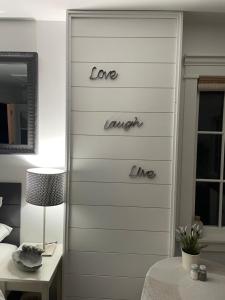 a bedroom with a wall with the words love laugh line at Amante Luxury Bed & Breakfast in Victoria
