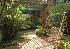 a swing in the middle of a garden at Villa Guest House in Bangkok