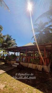 un edificio de madera con el sol en el cielo en La Voi del Mare, en Grand Anse