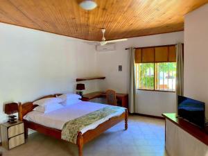 Schlafzimmer mit einem Bett und einem Flachbild-TV in der Unterkunft La Voi del Mare in Grand Anse